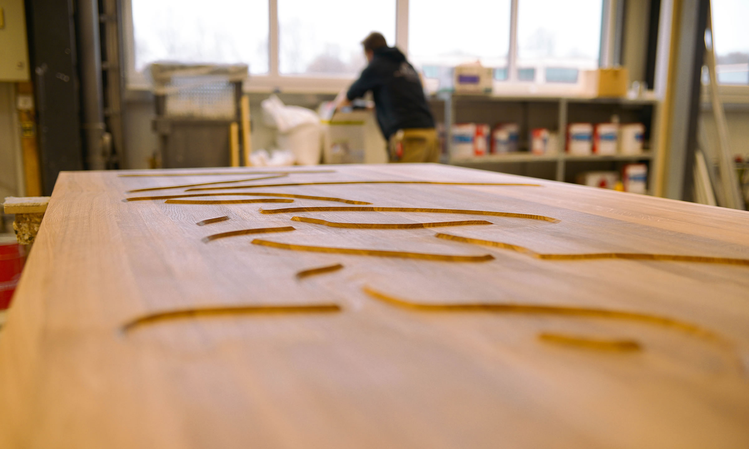 Blick in die Werkstatt von RvE mit verziertem Holztürblatt im Vordergrund