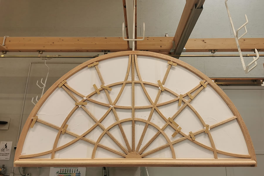 RvE-Tischlerei, Filigraner Fensterrahmen eines Rundbogenfensters zum Trocknen aufgehängt