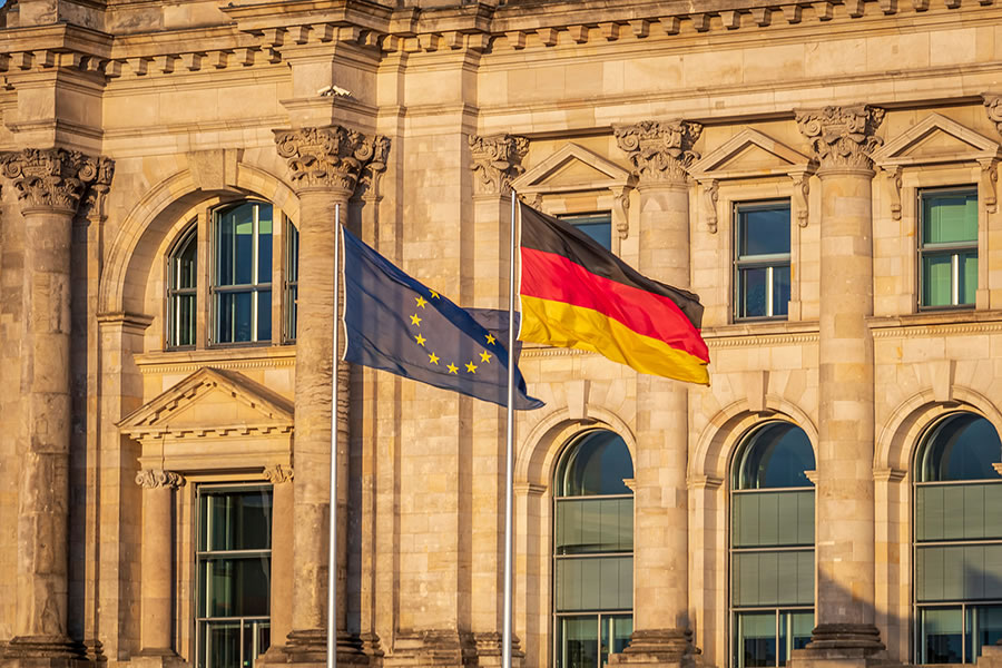 Deutschlandflagge und Flagge der Europäischen Union vor historischem Gebäude