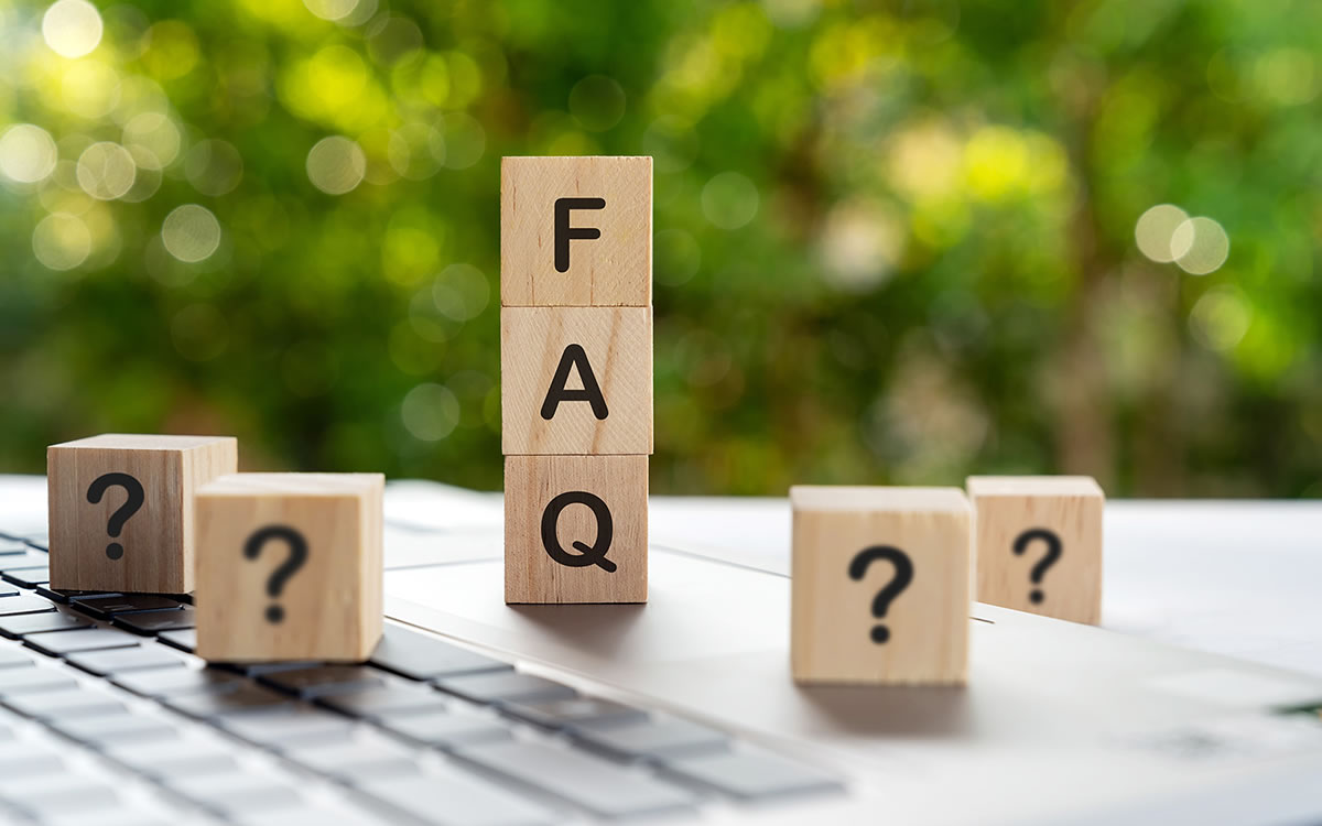 Holzwürfel mit Fragezeichen und FAQ-Buchstaben